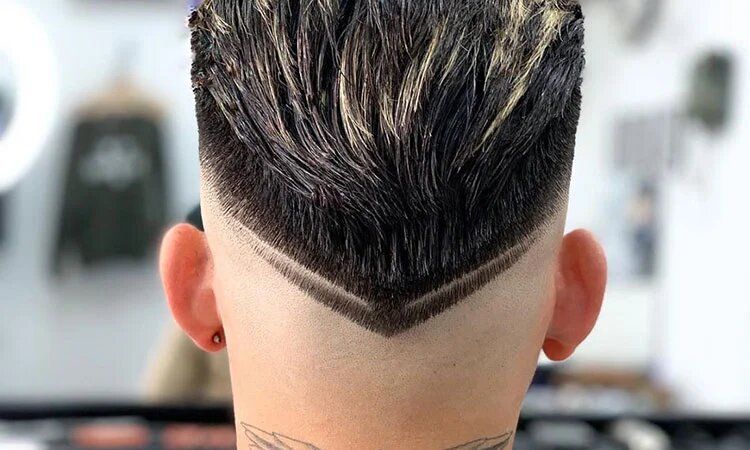 Close-up of a V fade haircut on a man with textured hair