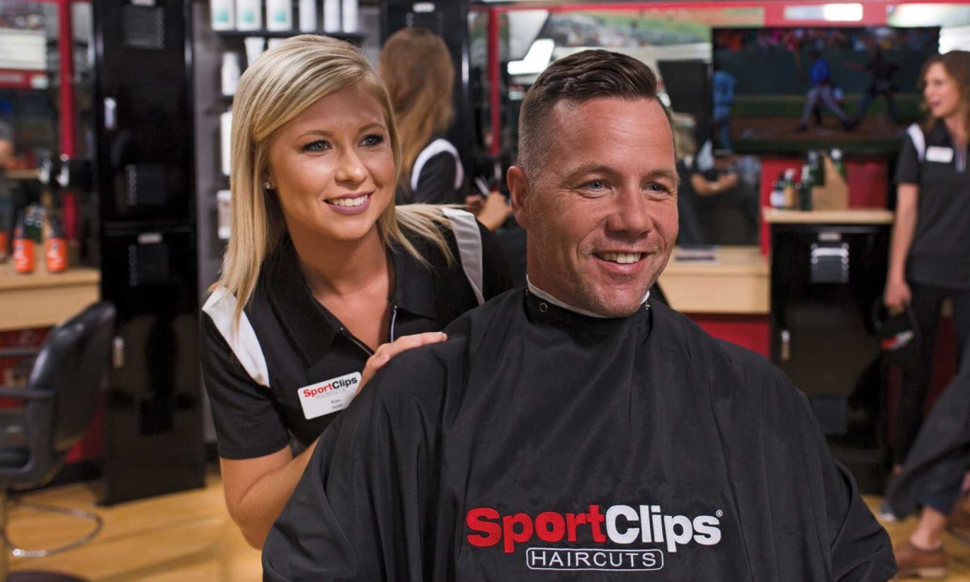 Professional barber at Sports Clips providing a haircut to a male customer